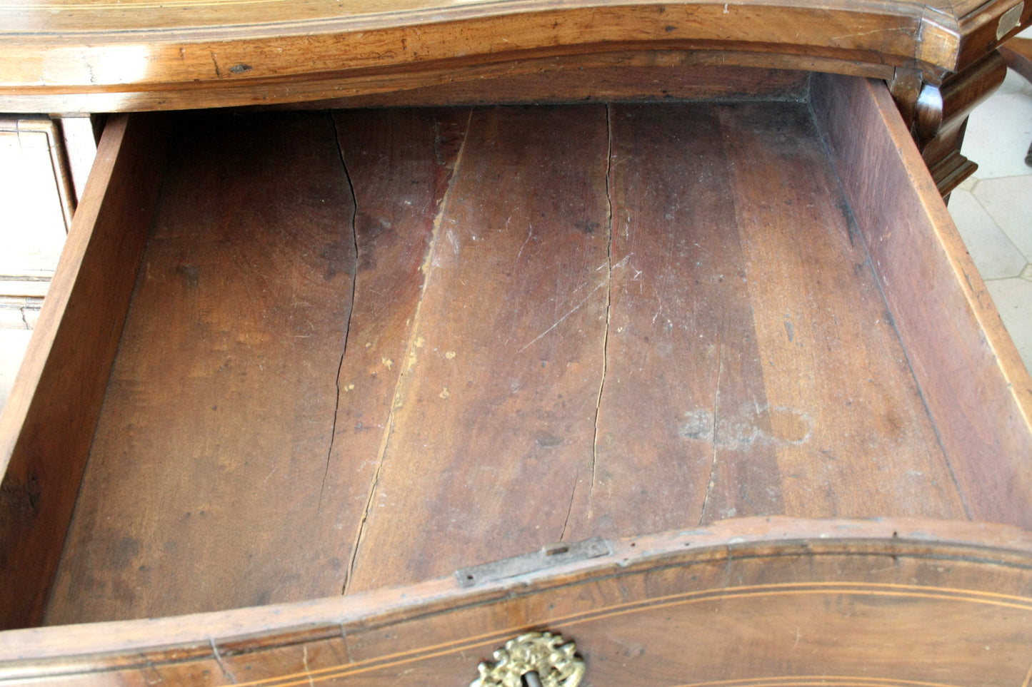 Antico cassettone in legno vintage aperto con interno usurato e crepe, design casa