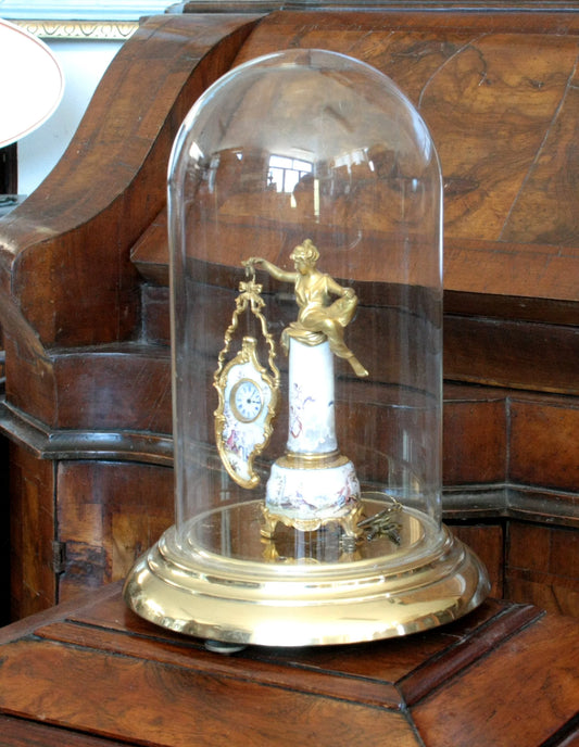 Bronze table clock with enamels under a 19th century glass dome, base with a gallant scene and a female figure