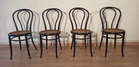 Four black bent beech dining chairs in the Thonet Italia style set arranged in a row