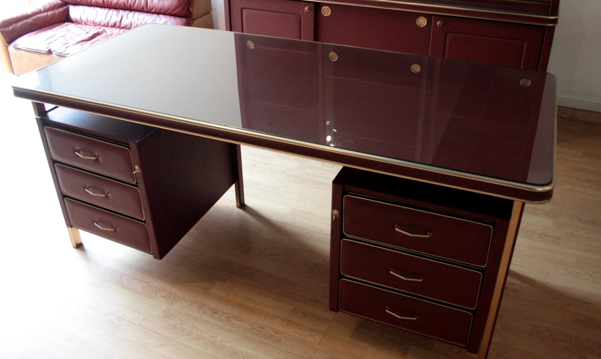 Scrivania e sedie di Umberto Mascagni in similpelle bordeaux con piano in vetro