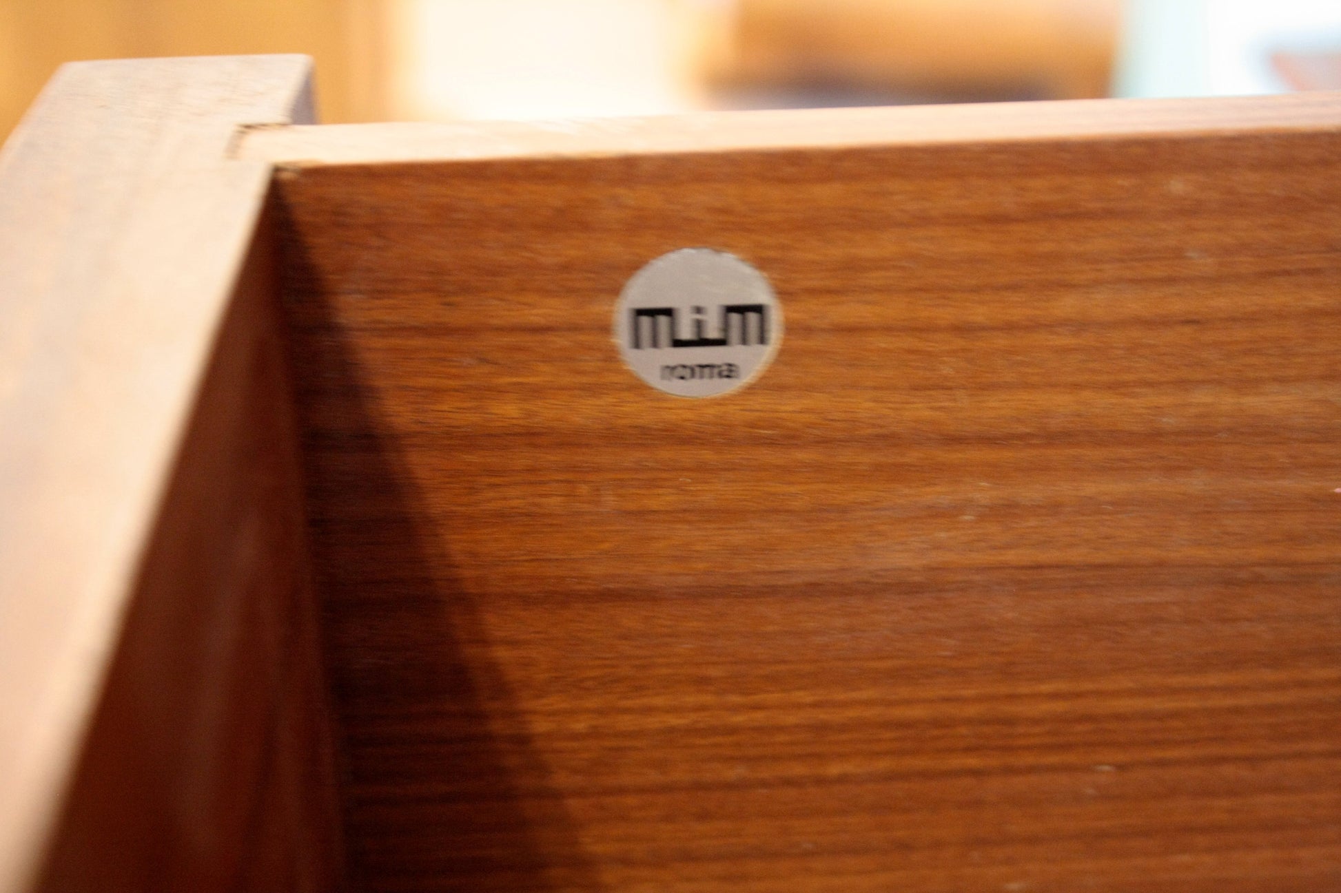 Dettaglio drawer in legno con adesivo del produttore su parete modulare Urio di Luisa Parisi