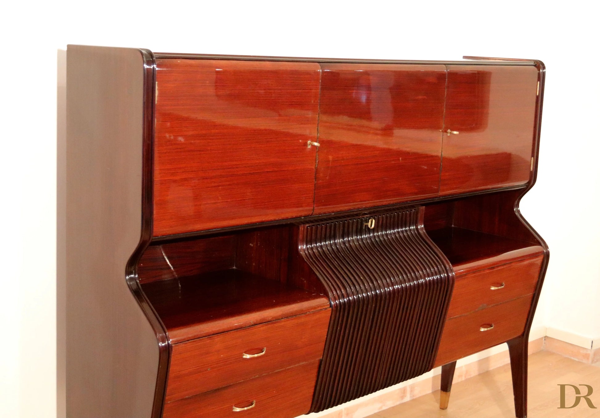 Credenza di Osvaldo Borsani in mogano lucido con cassetti e ante curve con maniglie dorate anni 50