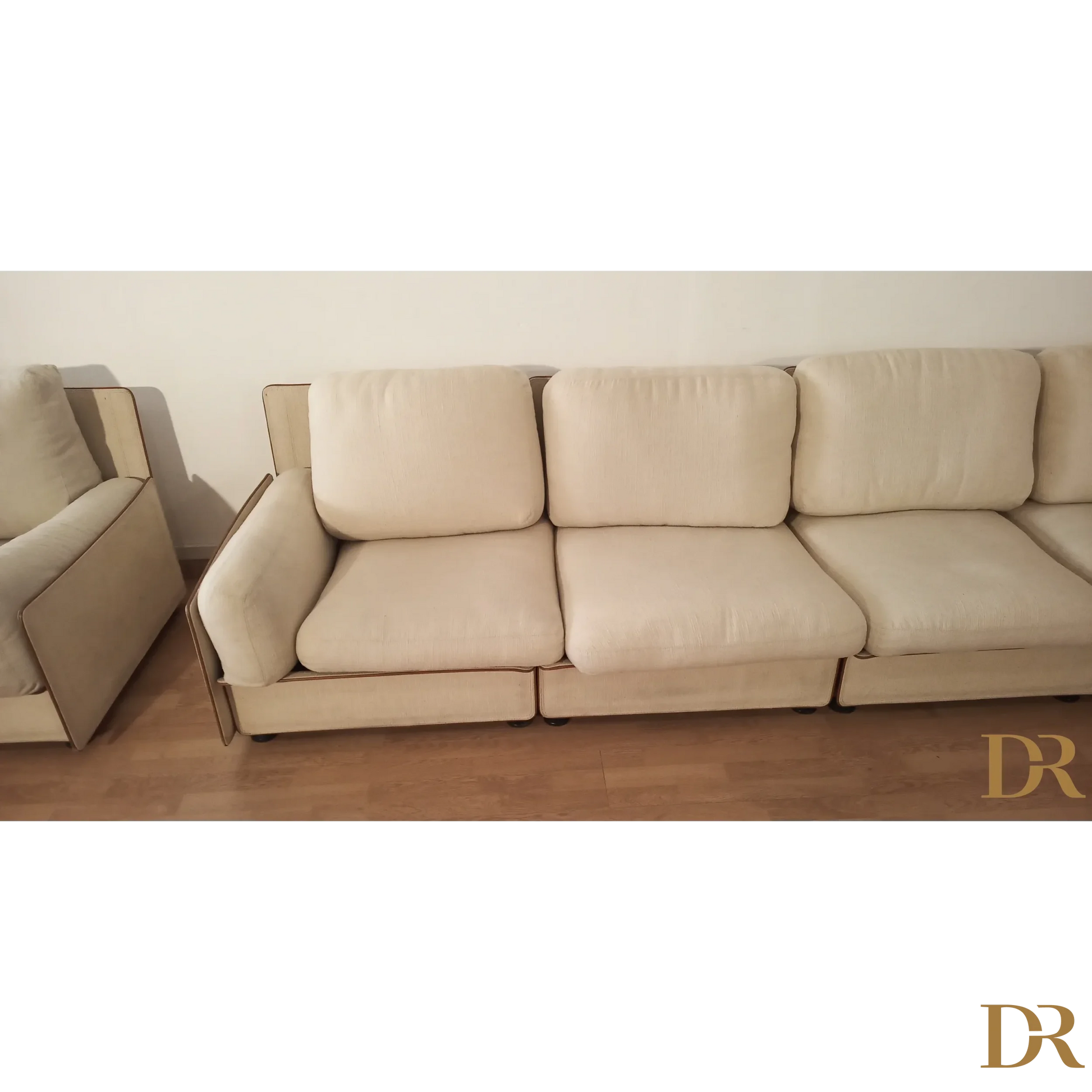 Divano modulare di Riccardo Arbizzoni con tre cuscini color crema e design elegante