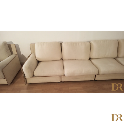 Divano modulare di Riccardo Arbizzoni con tre cuscini color crema e design elegante