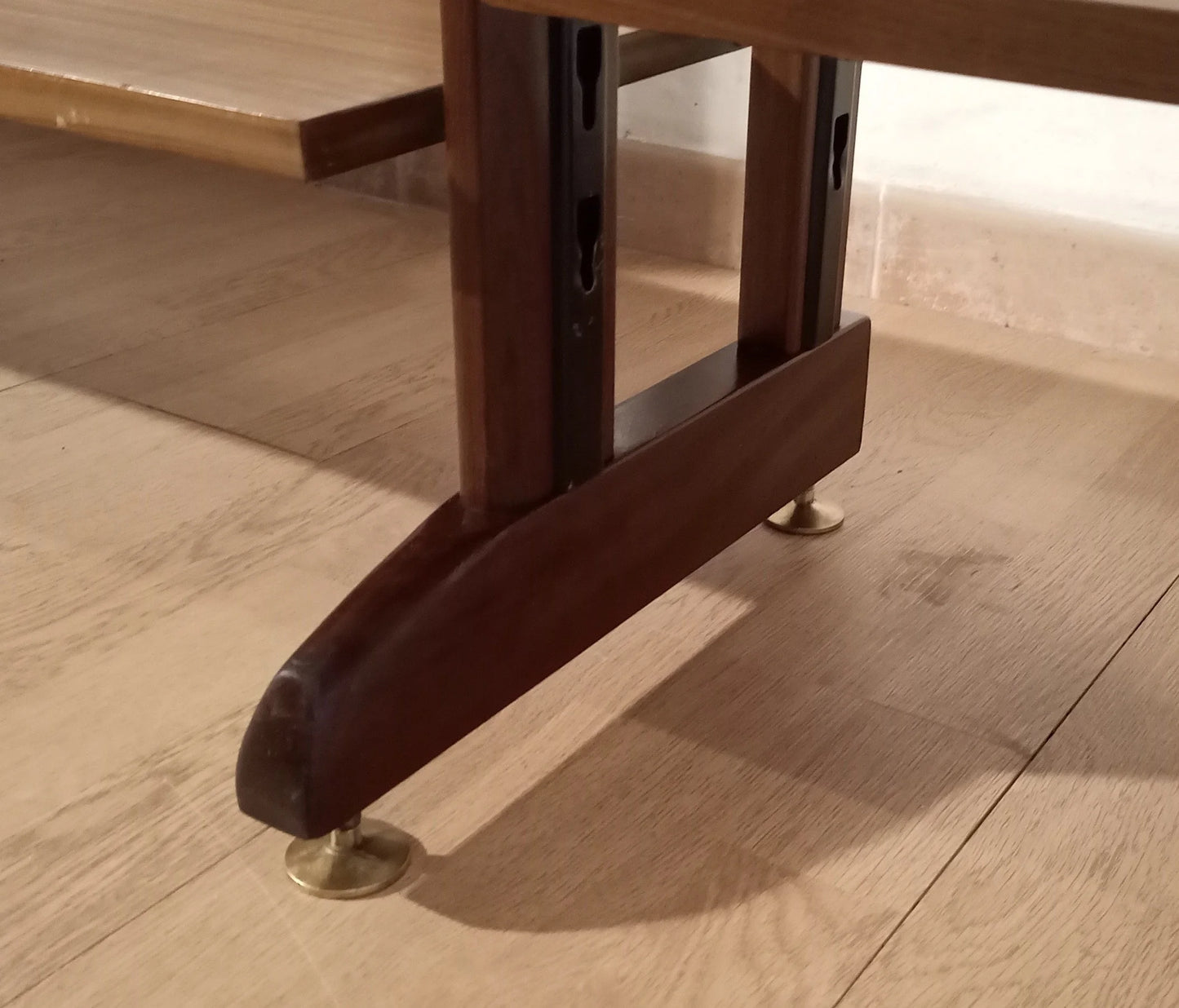 Gamba in legno scuro con piedi in metallo di libreria vintage modulare originale in teak su pavimento in legno