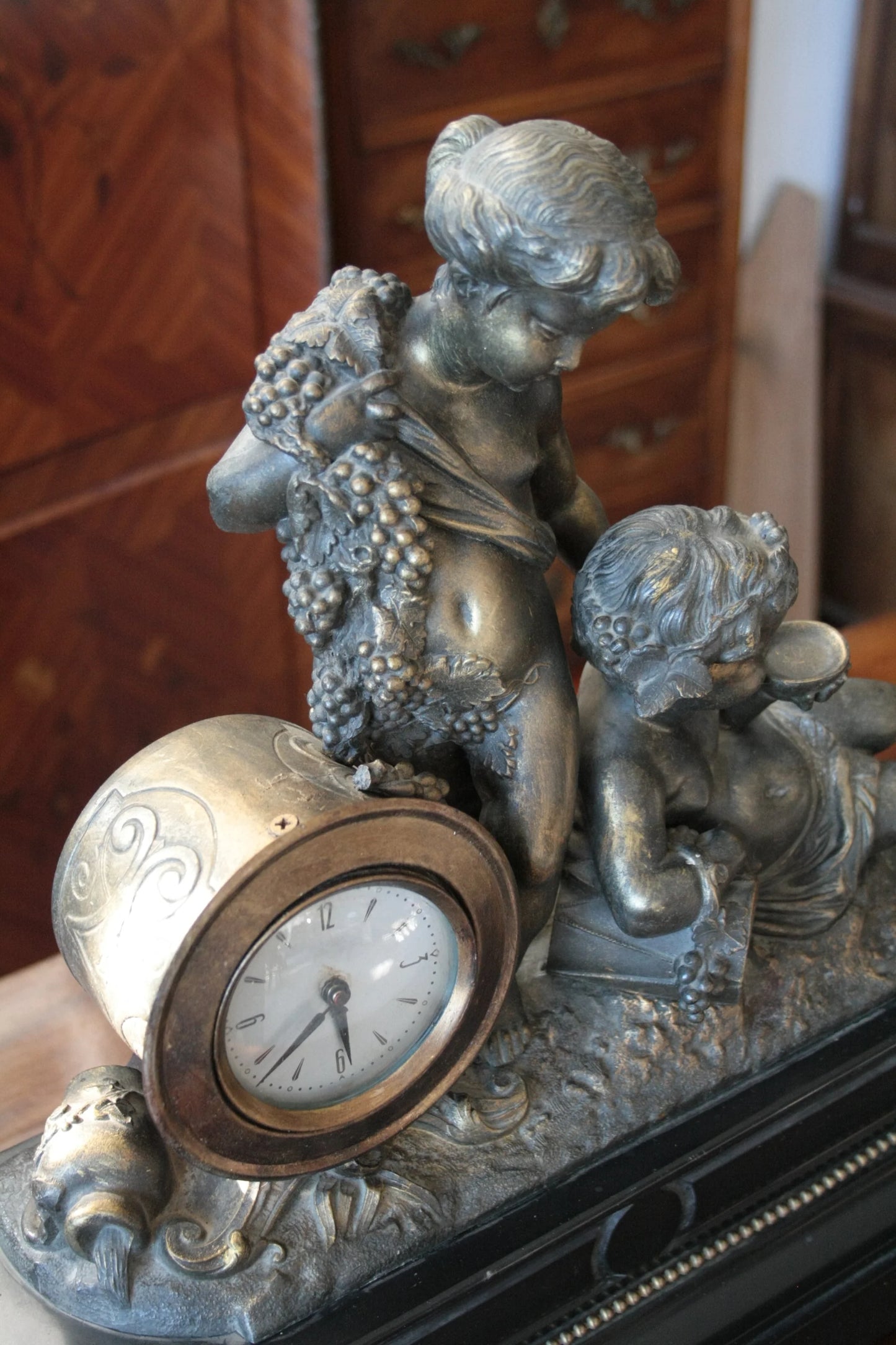 Orologio napoleone iii francese in bronzo ottone xix secolo con due putti in metallo che tengono grappoli d uva