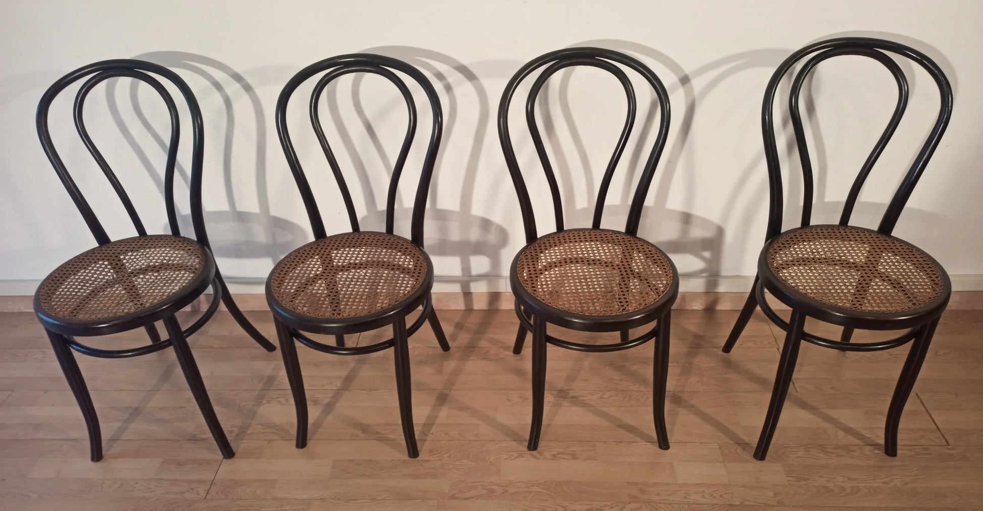 Quattro sedie da pranzo in faggio curvato con seduta in paglia nello stile thonet italia set disposte in fila